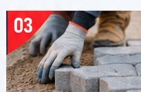 Worker laying interlocking paver blocks by hand